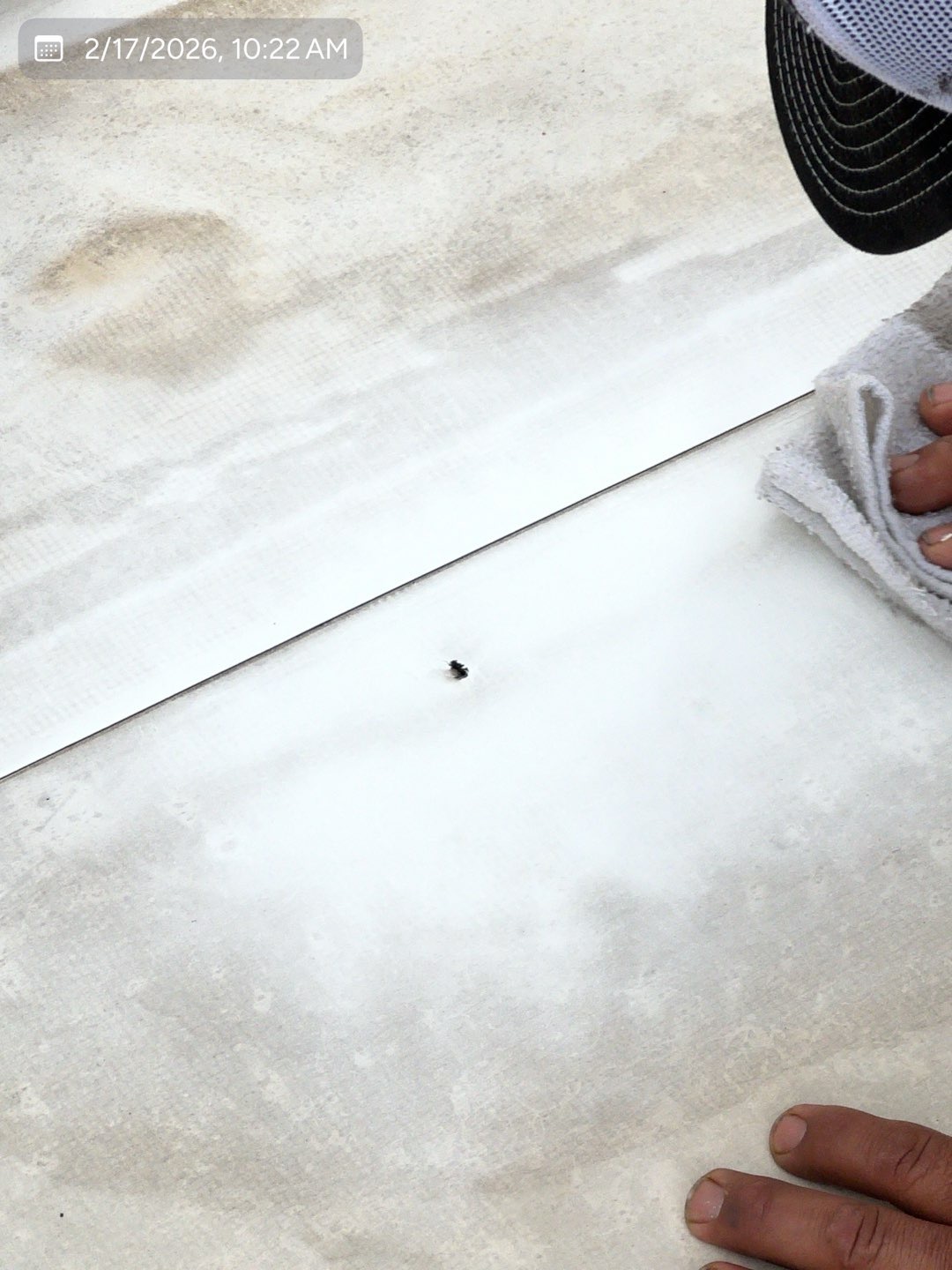 Commercial TPO membrane being cleaned and prepared for repair