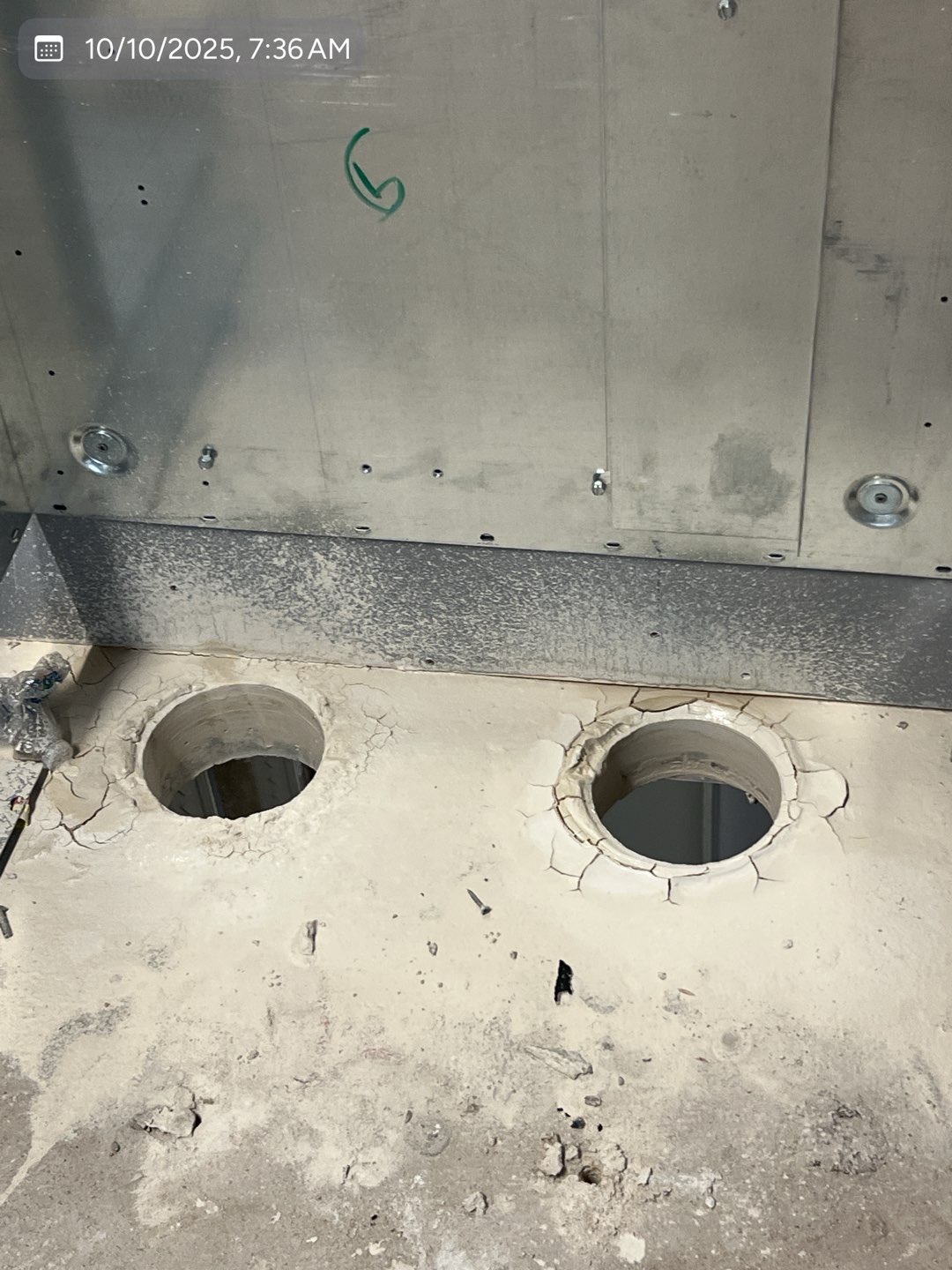 Two completed core-drilled openings in a commercial concrete floor