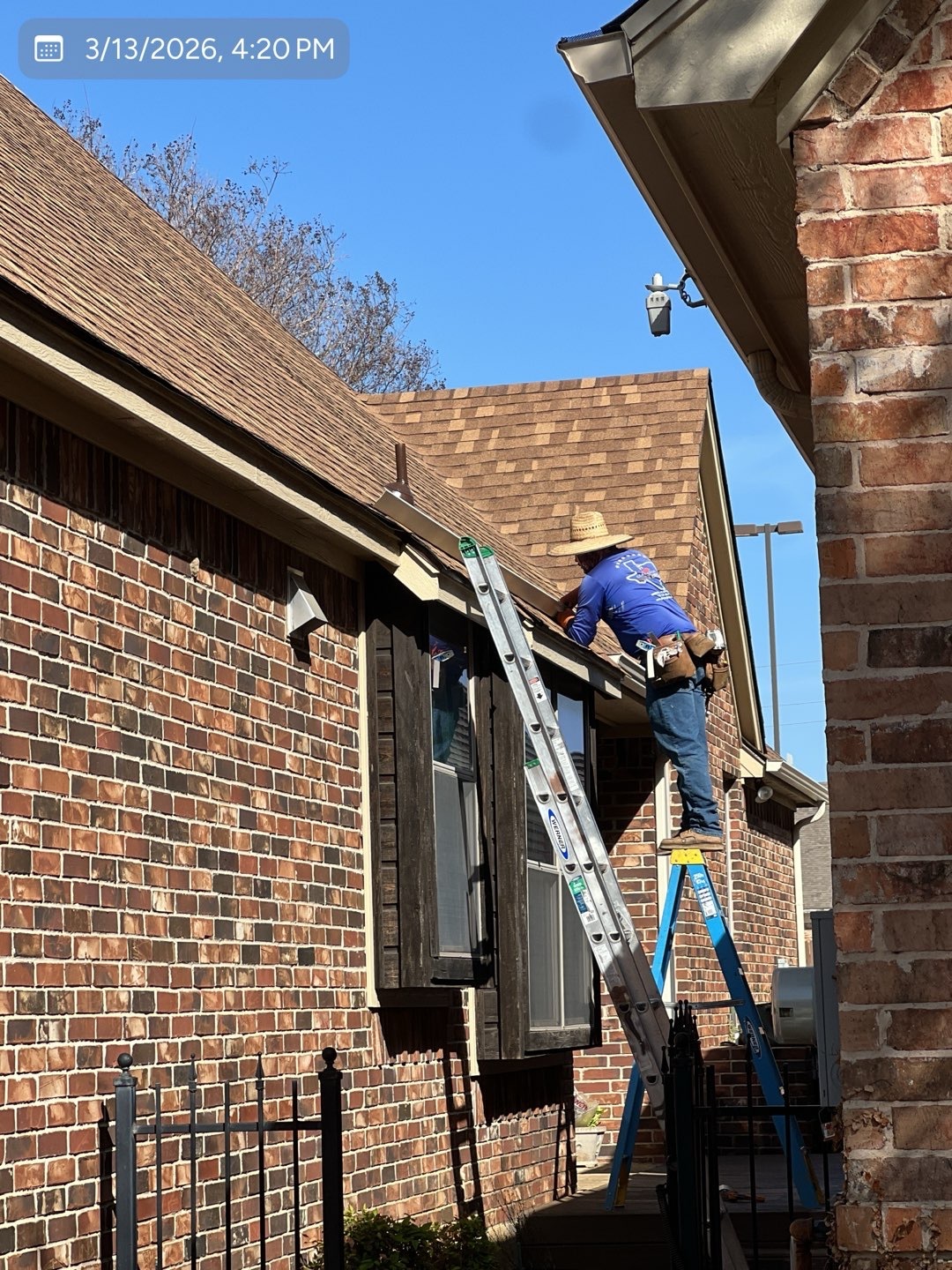 MVP crew member securing a gutter along a residential roofline