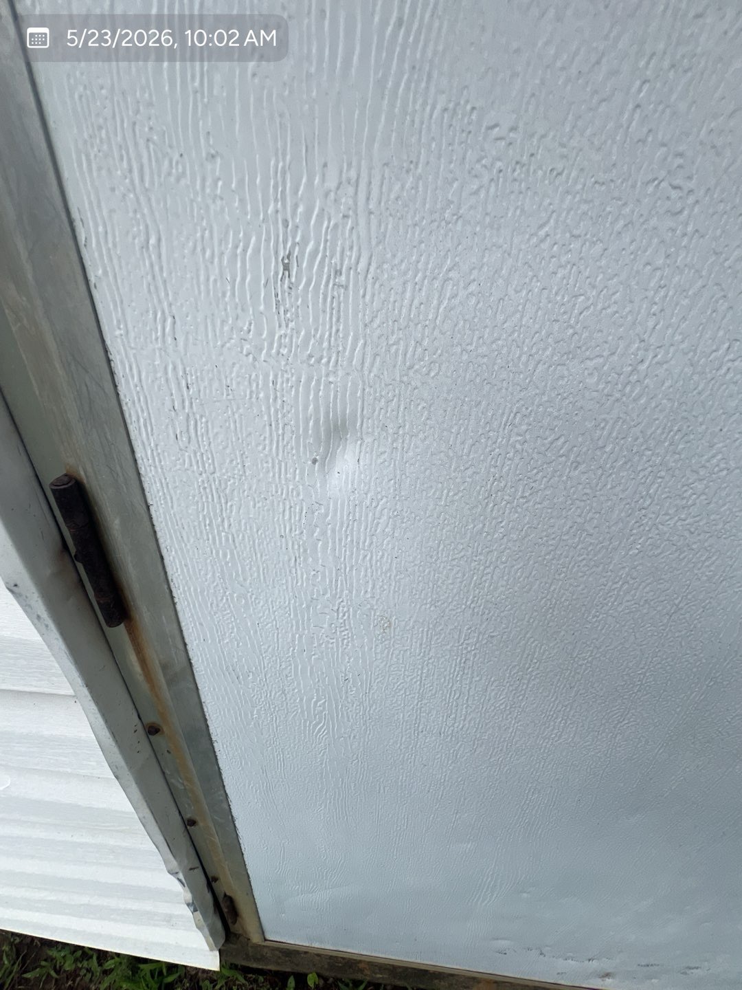 Hail impact dents visible on an exterior metal panel